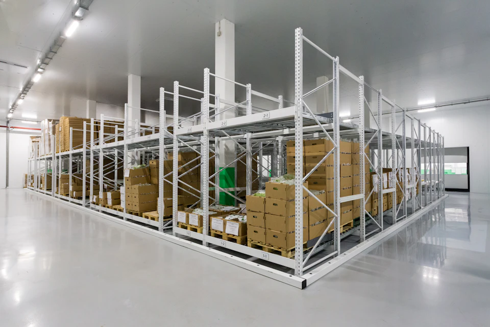 A bright, clean stockroom with boxed stock on white racking, ready to go out.