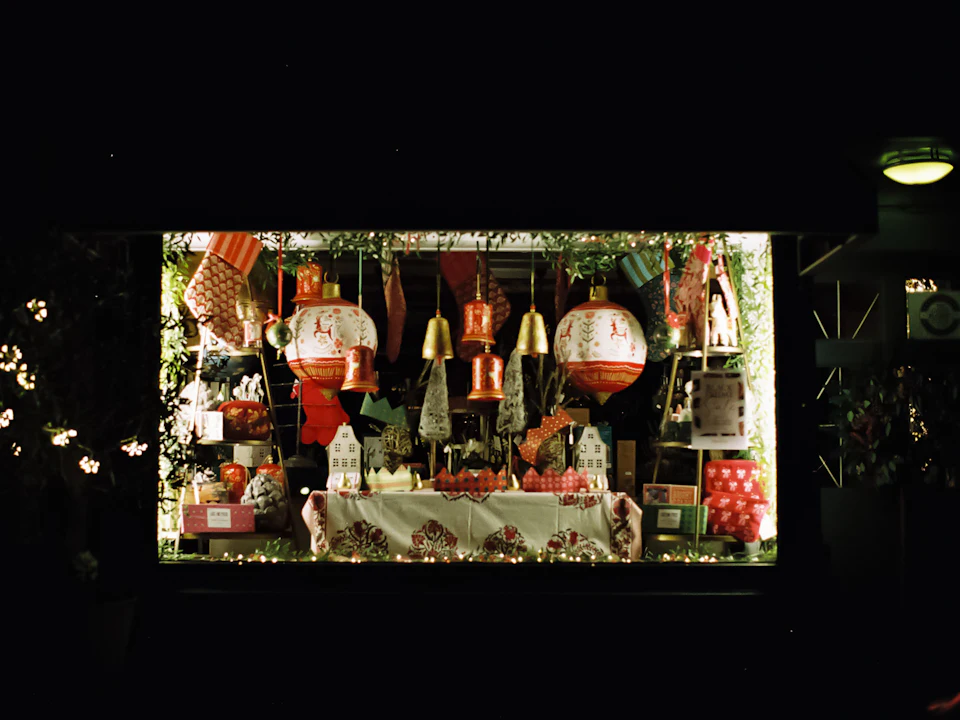 An illuminated shop window display seen from the pavement at night.