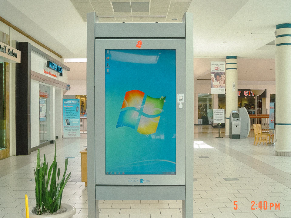 A tall digital display standing in a shopping centre walkway.