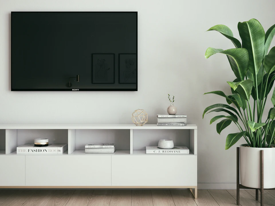 A flat screen mounted on a plain white interior wall.