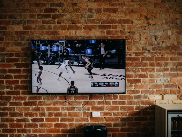 A flat screen mounted on an exposed brick wall.